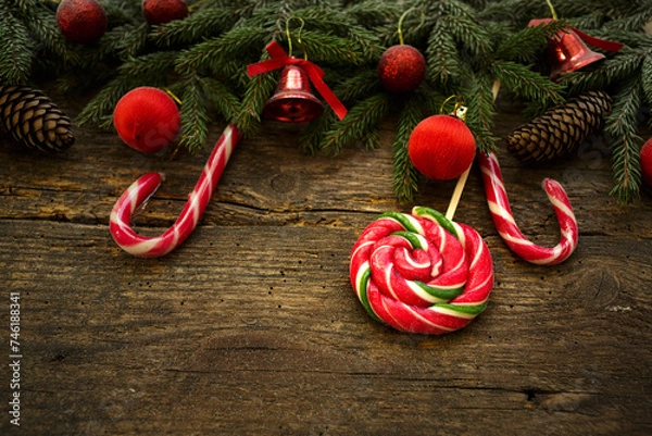 Obraz Christmas border with fir tree branches, cones, christmas decorations and candy cane on rustic wooden boards