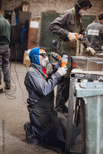 Fototapeta men cutting steel with angle grinder