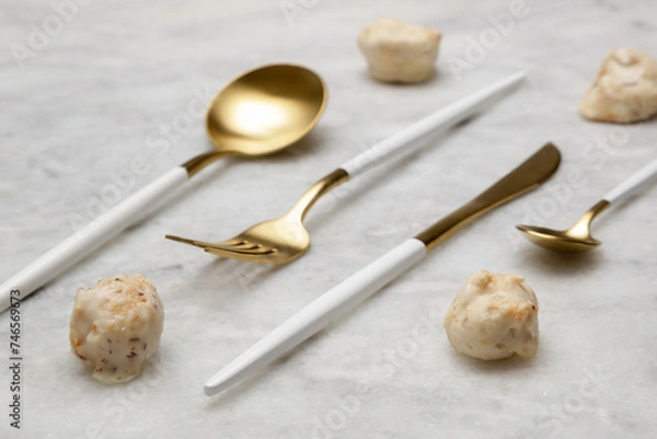 Fototapeta Creative shot of golden cutlery on marble table, Design concept. Modern kitchen. Scandinavian style tableware.	
