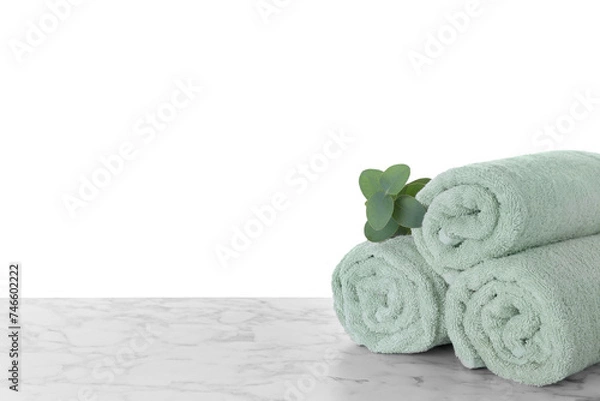 Fototapeta Fresh towels and eucalyptus branch on marble table against white background. Space for text
