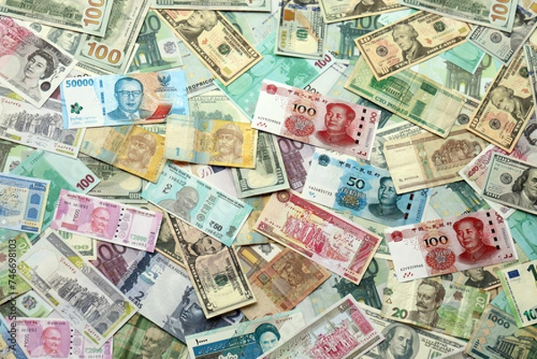 Fototapeta Many banknotes of different currency. Background of big amount of random money bills close up