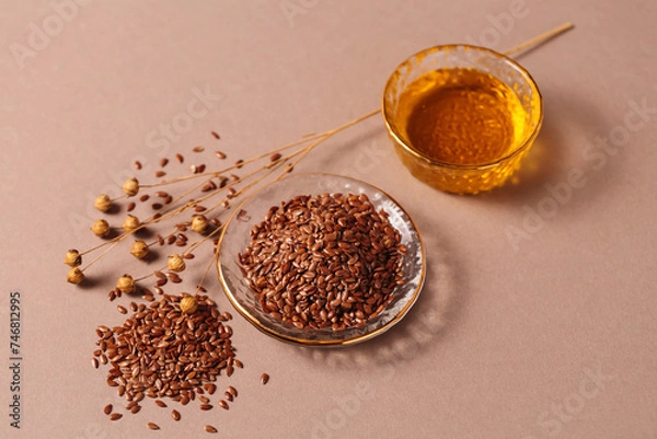 Obraz Brown linen seeds, flaxseed vegetable oil on beige background. Healthy super food