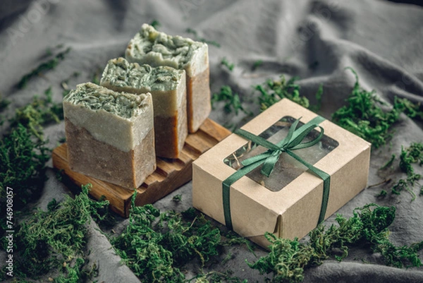 Fototapeta Pieces of authentic craft organic soap on a wooden soap dish surrounded by green moss. Concept of natural cosmetics made from safe, eco friendly ingredients