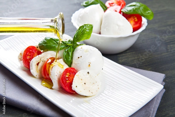 Obraz pomidor i mozzarella z liśćmi bazylii