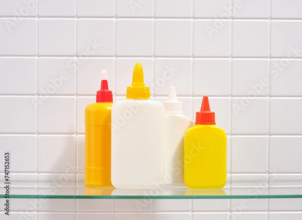 Fototapeta Several bright tubes different sizes of office glue. Office supplies.