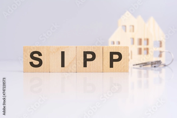 Obraz wooden cubes on a table with text SIPP, model house and keys on background. concept of business, financial, investment, economy. gray background