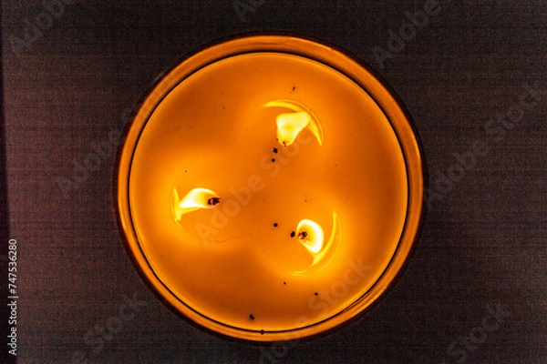 Obraz Close up Three Wick Candle Burning in Dark Room