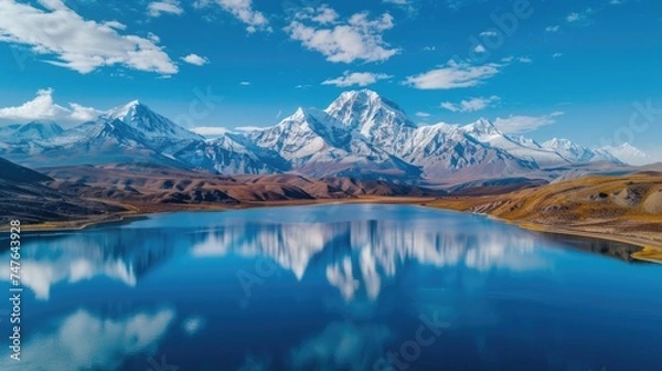 Fototapeta Alpine Lake Reflections: Snow-Capped Mountains Mirrored in Tranquil Waters