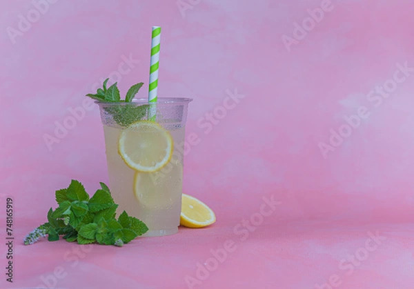 Fototapeta Lemoniada z miętą na lato. Zimny napój na lato. Miętowo cytrynowa lemoniada na różowym i szarym tle. Zmrożony napój na ochłodę. 