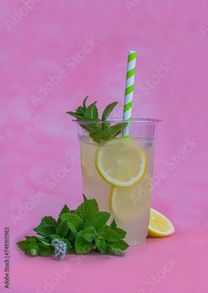 Fototapeta Lemoniada z miętą na lato. Zimny napój na lato. Miętowo cytrynowa lemoniada na różowym i szarym tle. Zmrożony napój na ochłodę. 