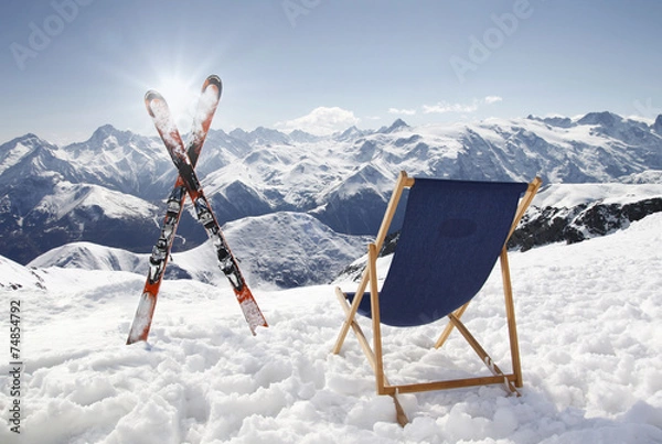 Obraz Cross ski and Empty sun-lounger at mountains