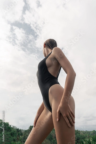 Obraz Sexy girl with a perfect figure posing in swimwear in the tropics