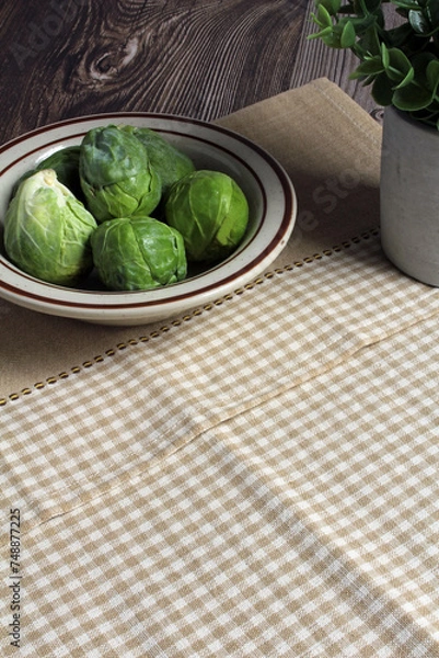 Obraz Fresh Brussels sprouts in a bowl, ready to cook. Space for text.