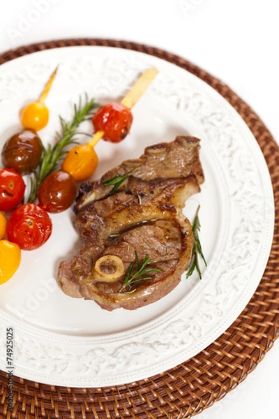 Fototapeta Lamb Chops with cherry tomato. Selective focus.
