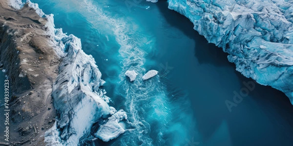 Fototapeta Aerial view of a melting glacier edge with floating icebergs in icy blue waters.