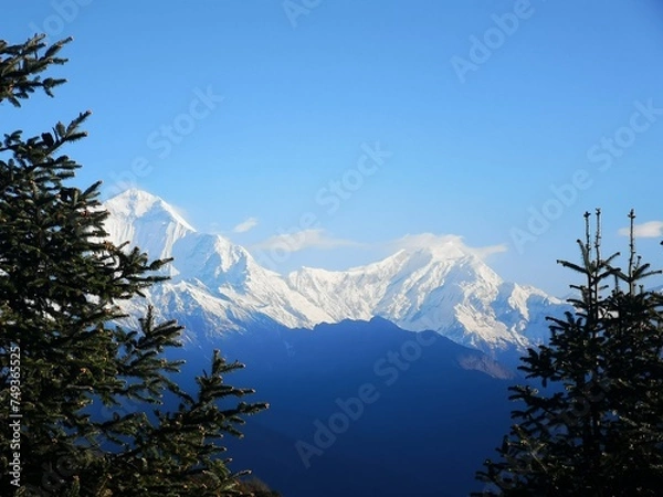 Fototapeta A majestic sight of towering peaks, their jagged outlines merging seamlessly with the endless expanse of the sky.