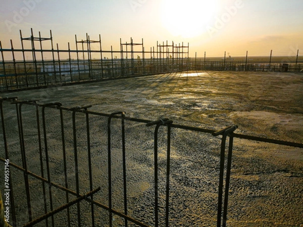 Fototapeta A construction site with a fence in the background. The fence is made of metal and is in the foreground