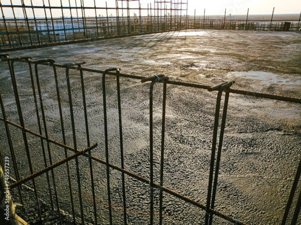 Fototapeta A construction site with a fence in the background. The fence is made of metal and is in the foreground