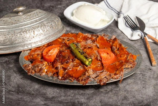 Fototapeta iskender kebab. Traditional Turkish cuisine flavor with tomato sauce and butter. iskender kebab on dark background