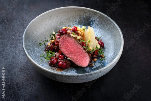 Obraz Traditionell gebratener Rehrücken mit Südtiroler mit Spätzle, Gemüse und Obst in Schokoladen Rotwein Sauce serviert als Nahaufnahme auf einem Nordic Design Teller mit Textfreiraum