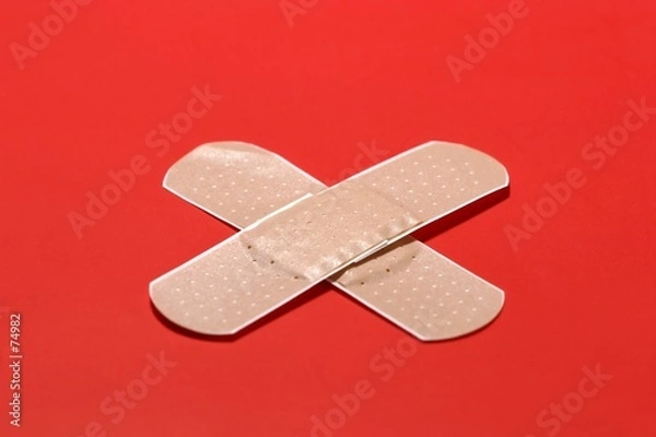 Obraz Two crossed adhesive bandages on red background