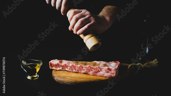 Fototapeta the chef adds spices to the meat