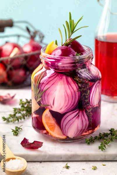 Fototapeta A jar of pickled red onions on a blue background.