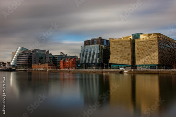 Fototapeta Dublin, Ireland, Dockland, modern building business center cityscape by Liffey river view during sunny day in background. europe
