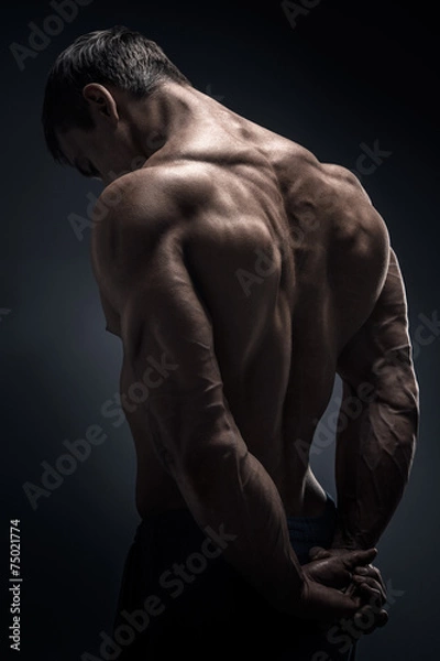 Obraz Handsome muscular bodybuilder turned back