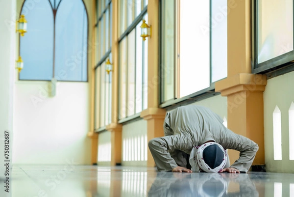 Fototapeta Ramadan, Muslim, Isalam, An Asian Muslim man is praying with peace in the beautiful mosque, giving a powerful atmosphere of faith, with copy space, Islam concept.