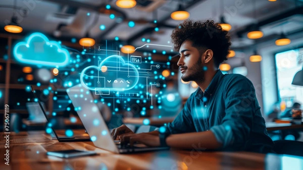 Fototapeta A focused young man engages with cloud technology graphics on a laptop at a modern workspace.