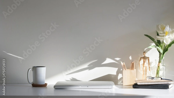 Fototapeta Home office interior. Houseplant, coffee cup, books and pencil holder on white table.