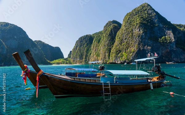 Obraz View of Maya bay with limestone rocks, white beach and blue clear water with long tail boats mooring in front of Bay. Phi-Phi Islands, Krabi, Thailand.
