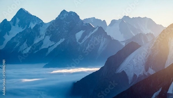 Fototapeta An image of epic mountains enveloped in morning fog, with sunlight casting a warm glow, creating a serene and majestic natural background.