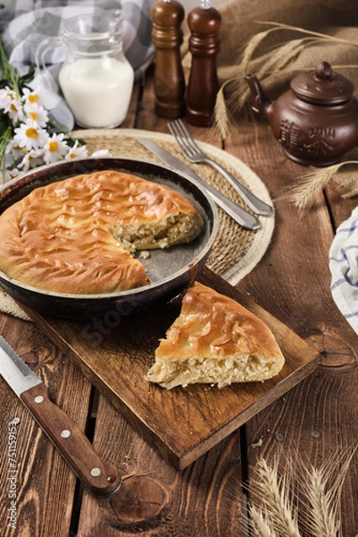 Fototapeta pie with cabbage and egg in a cut on a wooden background