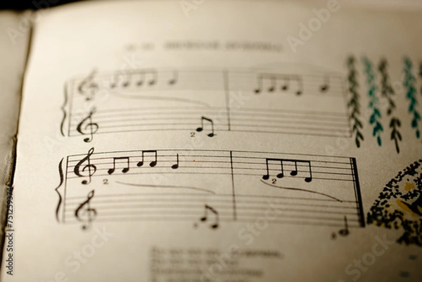 Obraz A page from a book with musical notes as a background, close-up view