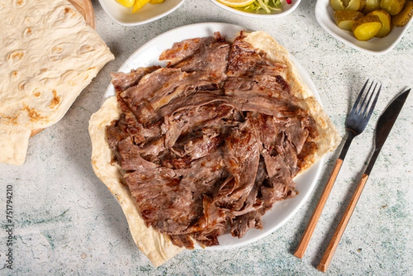 Fototapeta Meat doner kebab. Turkish and Middle Eastern cuisine flavors. Doner kebab on stone floor. Local name tabakta et döner
