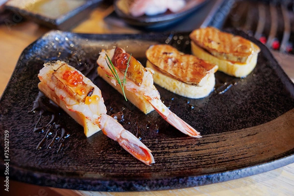 Fototapeta close up view of sushi shrimp nigiri on rice and foie gras in a plate