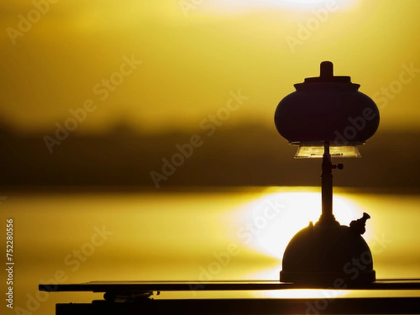 Fototapeta Light an oil lamp at dusk in the swamp.