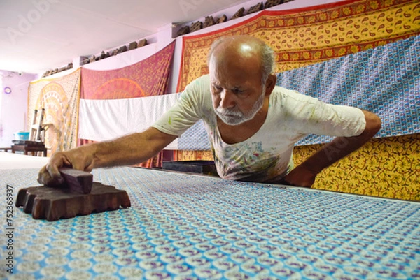 Fototapeta Artisan stamping patterns in ink on traditional Indian textiles as colorful sari
