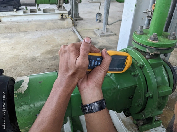 Obraz Man worker measure vibration motor and pump on power plant project. The photo is suitable to use for industry background photography, power plant poster and electricity content media.