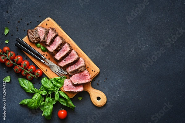 Fototapeta Beef with basil and tomatoes on a wooden board