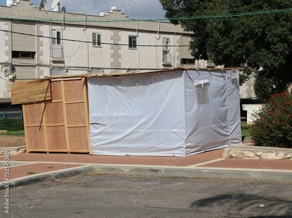Fototapeta Sukkah for Sukkot from wooden sides and sheets on the street