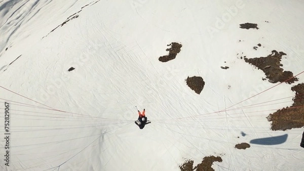 Obraz Tandem paraglider in the air on snow background. Paragliding in winter