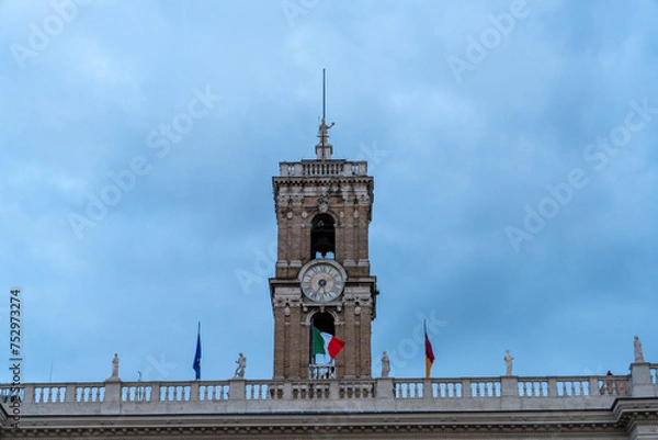Fototapeta A clock tower with a flag on top of it