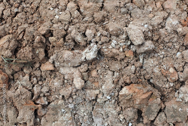 Fototapeta The texture of soil erosion after agricultural use. Clods of earth in an arable field. The soil needs fertilizers. 