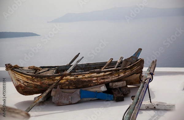 Fototapeta Weathered boat resting on Santorini rooftop, copy space.