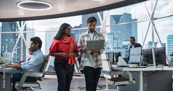 Obraz Young Team of South Asian Specialists Working on Desktop Computers at a Modern Workplace. Indian Software Developer Discussing a Financial Software Project with a Female Team Leader