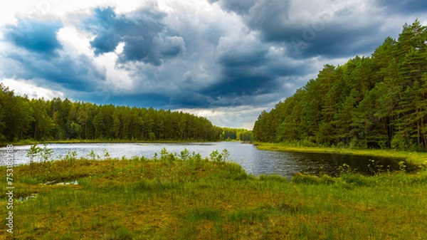 Fototapeta Beautiful mid-forest lake with magic and mysterious sky above it.