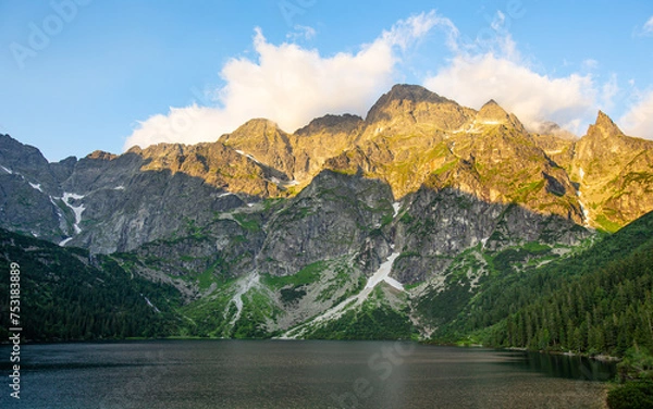 Fototapeta Tatra mountains in the morning with marshmallow of clouds above the top. View from lake named Eye of the Sea.